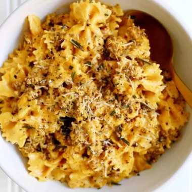 Cozy creamy pumpkin pasta topped with fresh herbs.