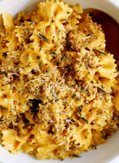 Cozy creamy pumpkin pasta topped with fresh herbs.