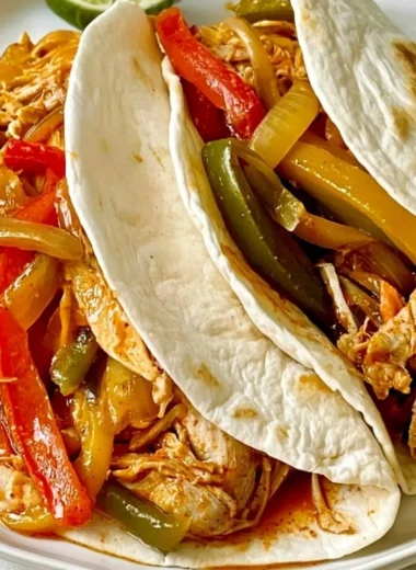 Slow cooker chicken fajitas served in a bowl with fresh toppings.