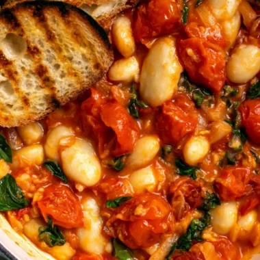 Creamy tomato basil butter beans dish garnished with fresh basil