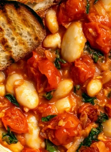 Creamy tomato basil butter beans dish garnished with fresh basil