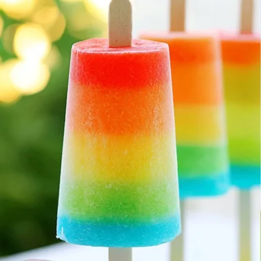 Colorful homemade rainbow popsicles stacked for a refreshing summer treat