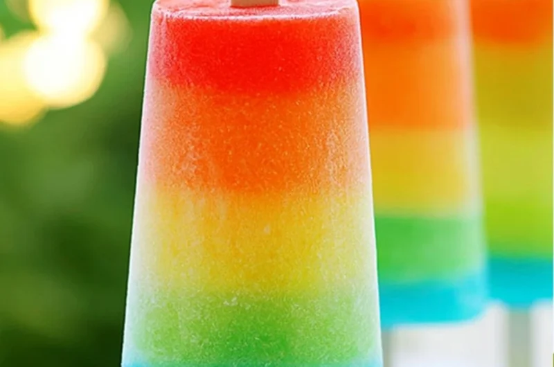 Colorful homemade rainbow popsicles stacked for a refreshing summer treat