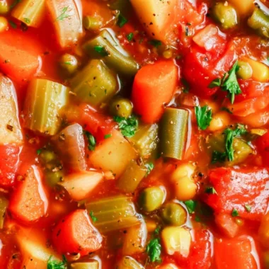 Bowl of hearty vegetable soup filled with fresh vegetables and herbs