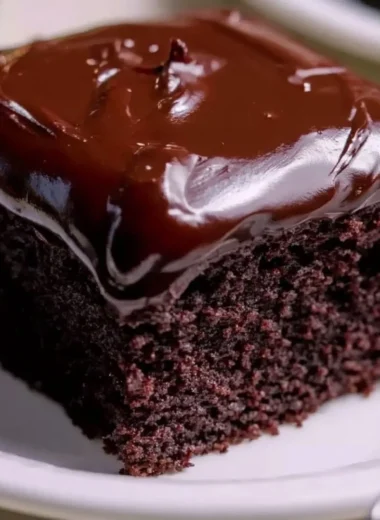 Wacky Chocolate Cake topped with colorful sprinkles and creamy chocolate frosting.