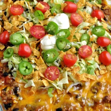 Delicious Walking Taco Casserole topped with cheese and fresh toppings