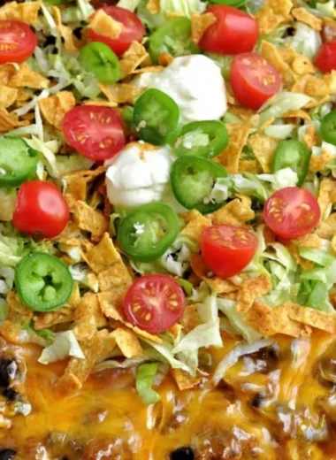 Delicious Walking Taco Casserole topped with cheese and fresh toppings