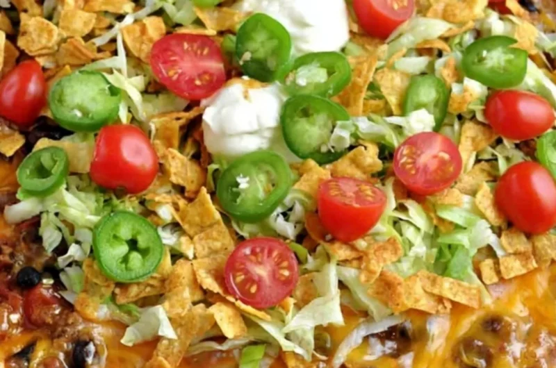 Delicious Walking Taco Casserole topped with cheese and fresh toppings