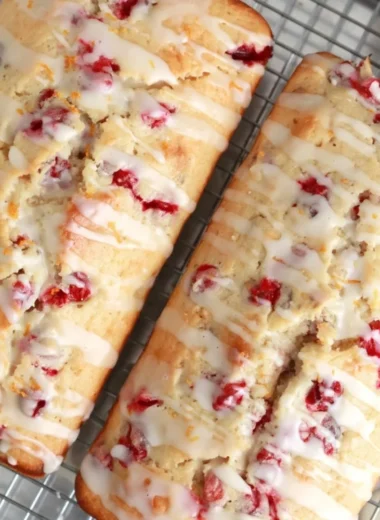 Freshly baked cranberry orange bread with cranberries and orange slices