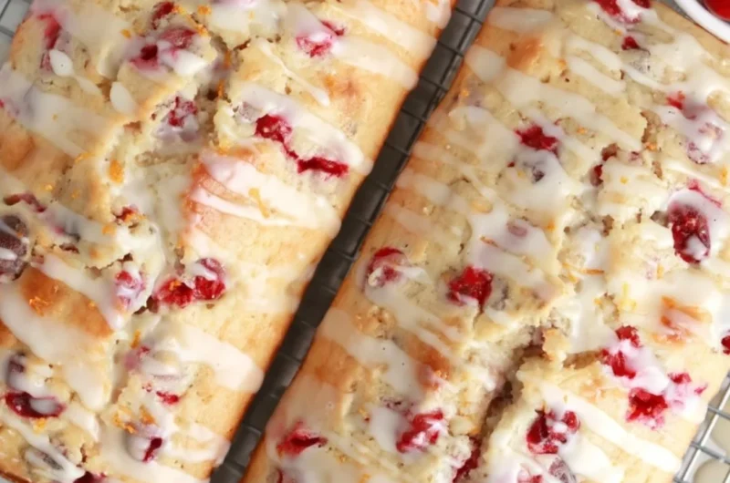 Freshly baked cranberry orange bread with cranberries and orange slices